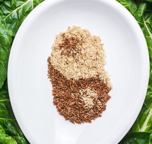 A top view of brown and white grains mixed in a white plate creating  ying and yang